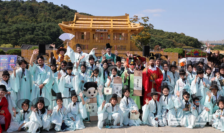 [수원=뉴시스] 김종택 기자 = 제63회 수원화성문화제가 열린 11일 경기도 수원시 화성행궁 광장에서 종이상자를 쌓아 만든 '시민의 위대한 건축 화홍' 을 배경으로 조선시대 과거시험 재현행사 참가자와 출연진들이 기념촬영을 하고 있다. 2026.10.11. jtk@newsis.com