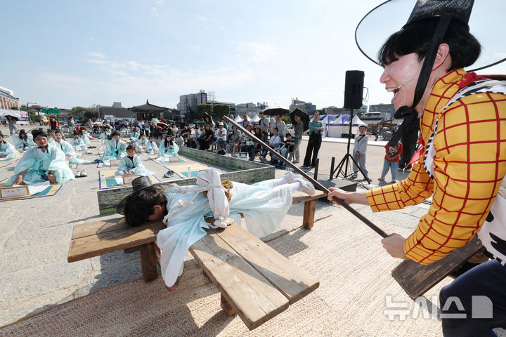 [수원=뉴시스] 김종택 기자 = 제63회 수원화성문화제가 열린 11일 경기도 수원시 화성행궁 광장에서 종이상자를 쌓아 화홍문을 실제 크기의 70%로 만든 '시민의 위대한 건축 화홍' 앞에서 조선시대 과거시험을 재현한 '별시'가 진행되고 있다. 2026.10.11. jtk@newsis.com