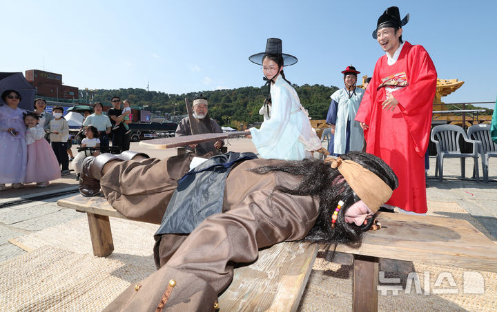 [수원=뉴시스] 김종택 기자 = 제63회 수원화성문화제가 열린 11일 경기도 수원시 화성행궁 광장에서 종이상자를 쌓아 화홍문을 실제 크기의 70%로 만든 '시민의 위대한 건축 화홍' 앞에서 조선시대 과거시험을 재현한 '별시'가 진행되고 있다. 2026.10.11. jtk@newsis.com