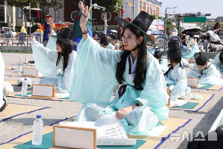 [수원=뉴시스] 김종택 기자 = 제63회 수원화성문화제가 열린 11일 경기도 수원시 화성행궁 광장에서 종이상자를 쌓아 화홍문을 실제 크기의 70%로 만든 '시민의 위대한 건축 화홍' 앞에서 조선시대 과거시험을 재현한 '별시'가 진행되고 있다. 2026.10.11. jtk@newsis.com