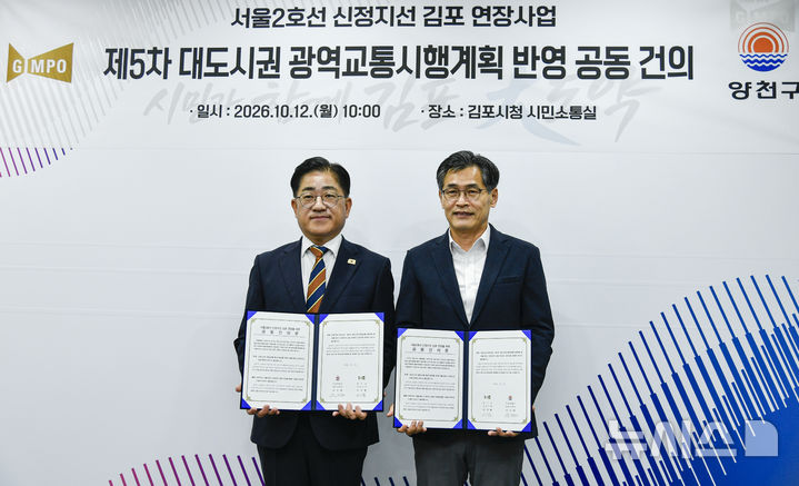 [김포=뉴시스] 이기형 경기 김포시장(왼쪽)과 이기재 양천구청장이 12일 김포시청에서 '서울2호선 신정지선 김포 연장사업의 제5차 대도시권 광역교통시행계획 반영을 위한 공동건의문'에 서명한 뒤 기념촬영을 하고 있다. (사진=김포시 제공) 2026.10.12. photo@newsis.com