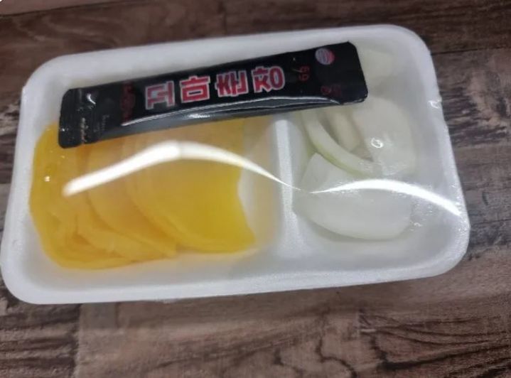 [서울=뉴시스] 중국 음식점에서 단무지와 양파 위에 일회용 춘장 포장지가 직접 닿은 채 포장된 것을 두고 네티즌들 사이에서 위생 문제에 대한 의견이 엇갈렸다. 사진은 온라인 커뮤니티에 공개된 단무지와 양파 포장 모습. (사진출처=온라인 커뮤니티) *재판매 및 DB 금지