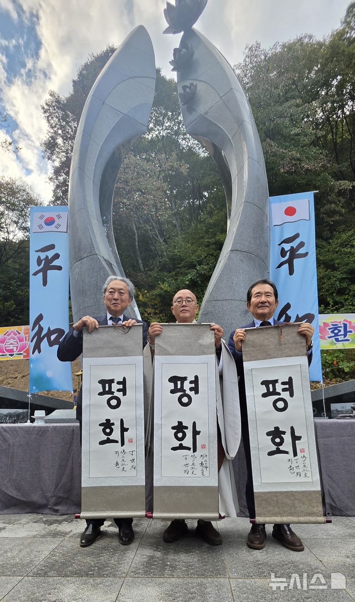 [옥천=뉴시스] 연종영 기자 = 정세균(사진 오른쪽) 전 국무총리와 하토야마 유키오(鳩山由紀夫, 사진 왼쪽) 전 일본 총리, 가산사 주지 지원스님이 12일 오후 옥천군 안내면 조계종 가산사 의승병충혼탑 앞에서 진행된 '제2회 한일평화의날' 행사에서 평화라고 쓴 족자를 펼쳐보이고 있다. 2026.10.12. jyy@newsis.com 