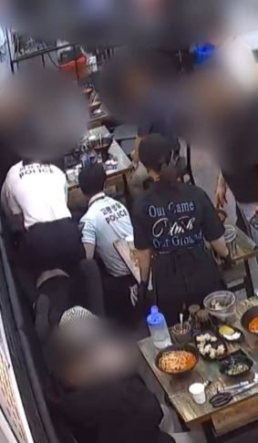 [서울=뉴시스] 인천의 한 짬뽕 전문점에서 식사하던 손님이 갑자기 쓰러지자 인근 테이블에 있던 경찰관들이 응급조치를 하고 있다. (사진출처=온라인 커뮤니티 보배드림 캡처) *재판매 및 DB 금지