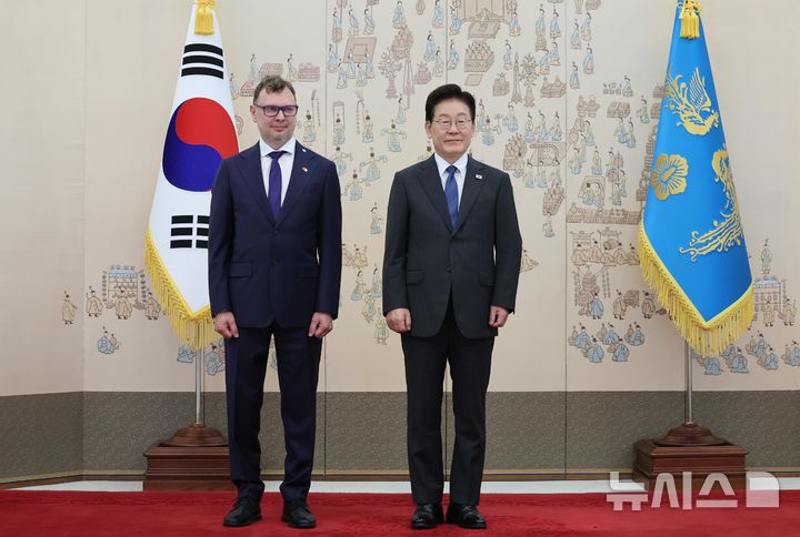 [서울=뉴시스] 조성봉 기자 = 이재명 대통령이 12일 청와대에서 열린 주한대사 신임장 제정식에서 도나타스 타물라이티스 주한리투아니아대사에게 신임장을 받고 기념 촬영을 하고 있다. (청와대통신사진기자단) 2026.10.12. suncho21@newsis.com