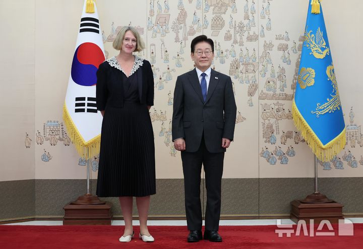 [서울=뉴시스] 조성봉 기자 = 이재명 대통령이 12일 청와대에서 열린 주한대사 신임장 제정식에서 미리암 테레사 모쥬간 주한슬로베니아대사에게 신임장을 받고 기념 촬영을 하고 있다. (청와대통신사진기자단) 2026.10.12. suncho21@newsis.com
