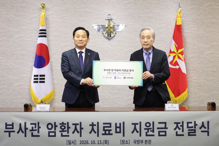 [서울=뉴시스] 13일 오후 국방부 청사에서 열린 '부사관 암환자 치료비 지원금 전달식'에서 대한암협회 이민혁 회장(오른쪽)이 이두희 국방부차관(왼쪽)에게 지원금 증서를 전달하고 있다. (사진=국방부 제공) 2026.10.13. photo@newsis.com *재판매 및 DB 금지