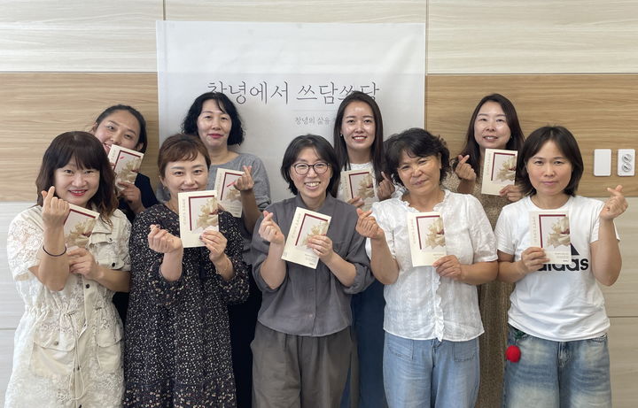 [창녕=뉴시스] 안지율 기자 = 참여자들이 출간된 공동 에세이집 창녕에서 쓰담쓰담을 들고 기념촬영을 하고 있다. (사진= 창녕군 제공) 2026.10.14. photo@newsis.com *재판매 및 DB 금지