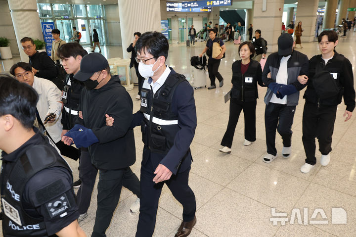 [인천공항=뉴시스] 황준선 기자 = 3조 1000억 규모의 불법 도박 조직을 운영한 부총책 B씨와 개발자 C씨가 14일 인천국제공항 1터미널을 통해 송환되고 있다. 범정부 합동 '초국가범죄 특별대응 태스크포스(TF)'는 아랍에미레이트(UAE) 당국과 공조해 국내 유명 인사들을 초청해 호화생활을 즐기는 등 10년간 해외 도피생활을 했던 불법 도박 조직 운영 총책 A씨와 부총책 B씨, 개발자 C씨를 3명을 현지에서 검거했다. 총책 A씨는 UAE 당국과 협의를 거쳐 송환될 예정이다. 2026.10.14. hwang@newsis.com