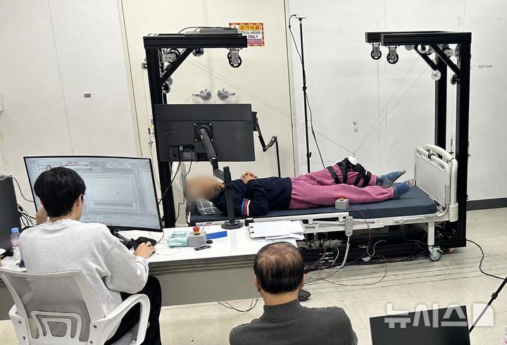 [전남광주=뉴시스] 필라테스봇 사용성 평가 현장. 참가자가 침대에 누워 다리 운동을 하고, 연구진이 운동 과정을 확인하고 있다. (사진=GIST 제공) photo@newsis.com *재판매 및 DB 금지