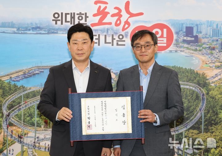 [포항=뉴시스] 포항시는 15일 신임 포항시립미술관장에 김석모 전 강릉솔올미술관장을 임용했다. 사진은 박용선(왼쪽) 시장이 김 신임 포항시립미술관장에게 임명장을 준 후 기념 촬영하고 있다. (사진=포항시 제공) 2026.10.15. photo@newsis.com