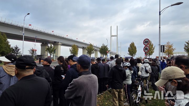 [단둥=뉴시스] 박정규 특파원 = 15일 오전 중국 랴오닝성 단둥에서 북·중 신압록강대교 개통 행사를 보기 위해 사람들이 몰려있다. 2026.10.15 pjk76@newsis.com