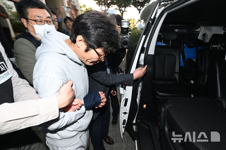 [전남광주=뉴시스] 이영주 기자 = 강도살인 혐의를 받는 박용수(53·가운데)가 16일 오전 전남광주 동구 동부경찰서에서 공소청으로 송치되고 있다. 박용수는 채무를 이유로 지인 60대 A씨 부부를 살해하고 현금카드를 빼앗아 달아난 혐의를 받고있다. 2026.10.15. leeyj2578@newsis.com