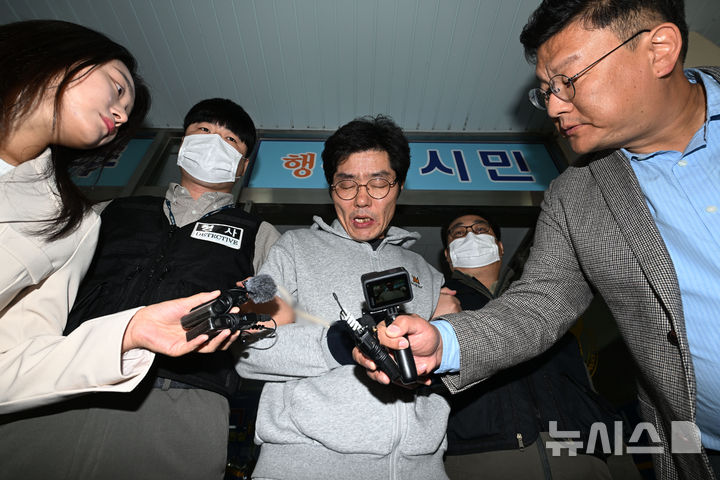 [전남광주=뉴시스] 이영주 기자 = 강도살인 혐의를 받는 박용수(53·가운데)가 16일 오전 전남광주 동구 동부경찰서에서 공소청으로 송치되고 있다. 박용수는 채무를 이유로 지인 60대 A씨 부부를 살해하고 현금카드를 빼앗아 달아난 혐의를 받고있다. 2026.10.15. leeyj2578@newsis.com
