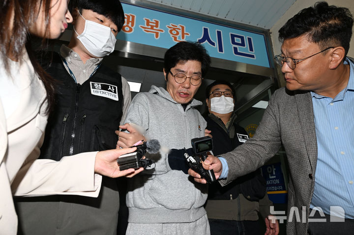 [전남광주=뉴시스] 이영주 기자 = 강도살인 혐의를 받는 박용수(53·가운데)가 16일 오전 전남광주 동구 동부경찰서에서 공소청으로 송치되고 있다. 박용수는 채무를 이유로 지인 60대 A씨 부부를 살해하고 현금카드를 빼앗아 달아난 혐의를 받고있다. 2026.10.15. leeyj2578@newsis.com