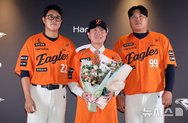 [대전=뉴시스] 배훈식 기자 = 류지현(가운데) 한화이글스 신임 감독이 16일 오후 대전 중구 대전한화생명볼파크에서 열린 취임식에서 채은성(왼쪽), 류현진에 꽃다발을 전달받고 기념촬영 하고 있다. 2026.10.16. dahora83@newsis.com