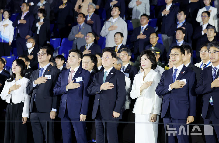 [제주=뉴시스] 김진아 기자 = 이재명 대통령과 김혜경 여사가 16일 제주월드컵경기장에서 열린 제107회 전국체육대회 개회식에서 국민의례를 하고 있다. 왼쪽 두번째부터 최휘영 문화체육관광부 장관, 유승민 대한체육회장, 이 대통령, 김 여사, 위성곤 제주도지사. (청와대통신사진기자단) 2026.10.16. bluesoda@newsis.com