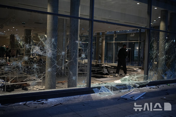 [리옹=AP/뉴시스] 17일(현지 시간) 프랑스 리옹에서 열린 생활비 상승 반대 시위에 참여한 한 남성이 약탈당한 상점 사진을 찍고 있다. 2026.10.19.