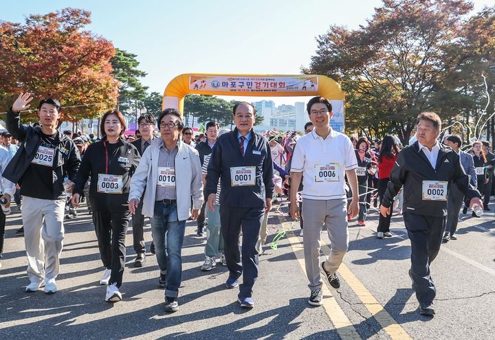 [서울=뉴시스] 유동균 마포구청장(가운데)이 17일 오전 ‘2026년 마포구민 걷기대회’에 참여해 주민들과 발맞춰 월드컵공원 평화광장을 나서고 있다. (사진=마포구 제공) 2026.10.18. photo@newsis.com *재판매 및 DB 금지