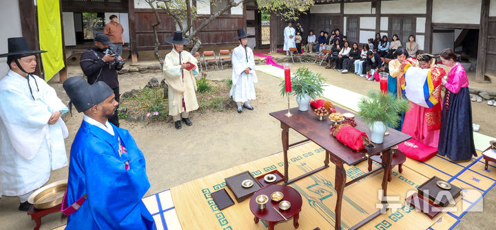 [경산=뉴시스] 이무열 기자 = 18일 경북 경산시 영남대학교 민속촌에서 열린 '경상북도 외국인 대상 전통혼례식'에서 스리랑카 부부가 전통 혼례를 올리고 있다. 이번 전통혼례는 경북도와 영남대학교 박물관이 도내 외국인 주민의 지역 정착을 돕기 위해 마련한 시범사업으로, 인도·스리랑카·가나·베트남 출신 부부 5쌍이 오는 25일까지 차례로 전통혼례를 올린다. 2026.10.18. lmy@newsis.com