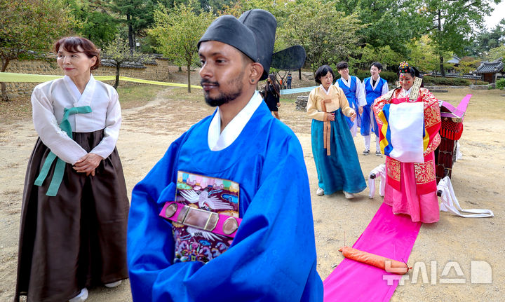 [경산=뉴시스] 이무열 기자 = 18일 경북 경산시 영남대학교 민속촌에서 열린 '경상북도 외국인 대상 전통혼례식'에서 스리랑카 부부가 전통 혼례를 올리고 있다. 이번 전통혼례는 경북도와 영남대학교 박물관이 도내 외국인 주민의 지역 정착을 돕기 위해 마련한 시범사업으로, 인도·스리랑카·가나·베트남 출신 부부 5쌍이 오는 25일까지 차례로 전통혼례를 올린다. 2026.10.18. lmy@newsis.com