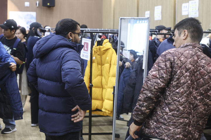 [화성=뉴시스] 화성시가 18일 '이주노동자 첫 겨울나기 나눔 행사'를 개최한 가운데, 행사에 참여한 이주노동자와 가족들이 겨울옷을 입어보고 있다. (사진=화성시 제공) 2026.10.19. photo@newsis.com *재판매 및 DB 금지
