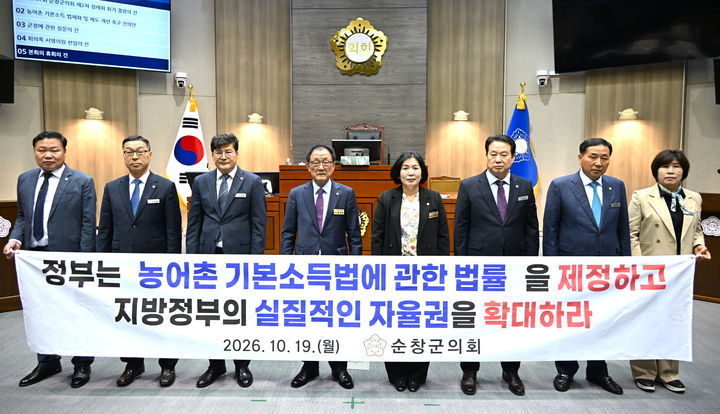 [순창=뉴시스] 19일 열린 순창군의회의 제307회 정례회 제1차 본회의, 김정숙 의원이 대표 발의한 '농어촌 기본소득 법제화 및 제도 개선 촉구 건의안' 낸의 현수막과 함께 오수환 의장(왼쪽 네번째) 등 군의원들이 사진을 찍고 있다. *재판매 및 DB 금지