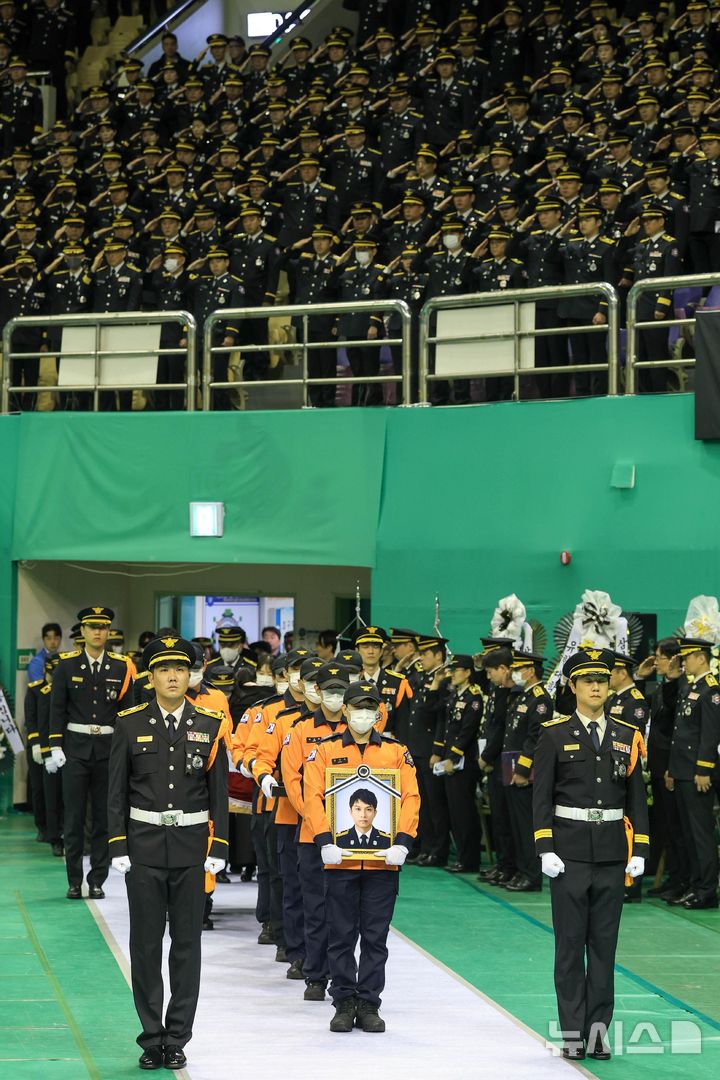 [부천=뉴시스] 전진환 기자 = 19일 경기 부천 원미구 부천체육관에 열린 '고(故) 김진석 소방위 영결식'에서 고인의 운구행렬이 영결식장으로 들어서고 있다. (공동취재) 2026.10.19. photo@newsis.com