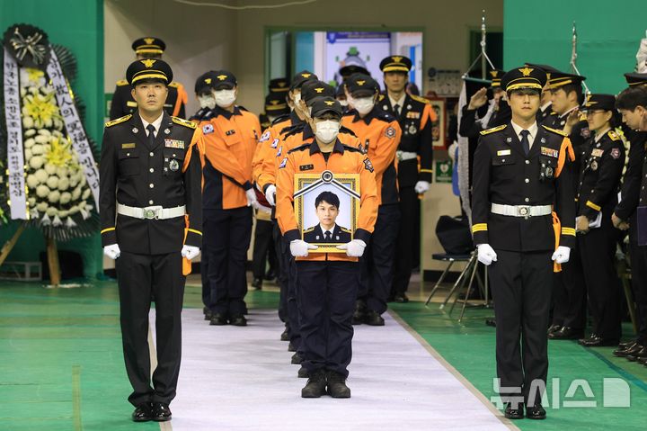 [부천=뉴시스] 전진환 기자 = 19일 경기 부천 원미구 부천체육관에 열린 '고(故) 김진석 소방위 영결식'에서 고인의 운구행렬이 영결식장으로 들어서고 있다. (공동취재) 2026.10.19. photo@newsis.com