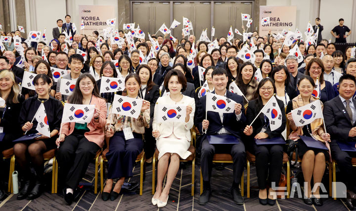 [서울=뉴시스] 조성봉 기자 = 김혜경 여사가 19일 서울 강님구 코엑스에서 열린 세계한인입양인협회(IKAA) 개더링 한국대회 개회식에서 토미 겐첼(오른쪽 네번째) IKAA 회장을 비롯한 참석자들과 태극기를 들고 기념 촬영을 하고 있다.2026.10.19. suncho21@newsis.com