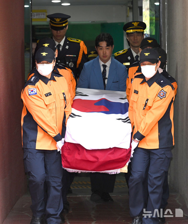 [부천=뉴시스] 전진환 기자 = 부천 공장 화재 진압 과정에서 순직한 김진석 소방위의 영결식이 엄수된 19일 경기도 부천시 원미구 부천체육관에서 동료 소방관들이 고인의 유해를 운구하고 있다. (공동취재) 2026.10.19. photo@newsis.com