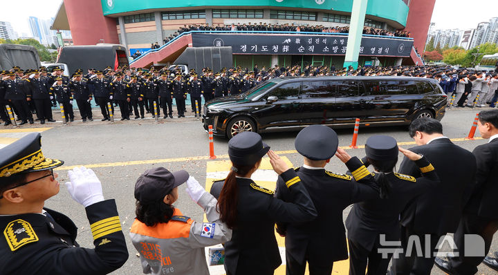 [부천=뉴시스] 전진환 기자 = 부천 공장 화재 진압 과정에서 순직한 김진석 소방위의 영결식이 엄수된 19일 경기도 부천시 원미구 부천체육관에서 동료 소방관들이 고인을 향해 경례하고 있다. (공동취재) 2026.10.19. photo@newsis.com