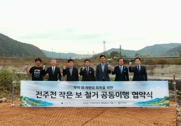 [서울=뉴시스] 글로벌 코카콜라 재단의 후원으로 추진되는 '전주천 작은 보 철거 공동이행 협약식'에 글로벌 코카콜라 재단, 기후에너지환경부, 재단법인 숲과나눔, 전북특별자치도, 완주군, 한국환경공단, 전북환경운동연합 등 총 7개 기관의 관계자들이 참석해 협약을 체결했다. 좌측부터 이정현 전북환경운동연합 공동대표, 이준엽 한국 코카콜라 대표, 장재연 (재)숲과나눔 이사장, 김성환 기후에너지환경부 장관, 이원택 전북특별자치도지사, 유희태 완주군수, 이준석 한국환경공단 환경시설이사 (사진=한국 코카콜라 제공) *재판매 및 DB 금지
