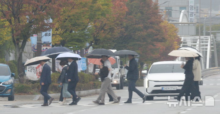 [전주=뉴시스] 김얼 기자 = 목요일인 29일은 쌀쌀한 가운데 오후부터 수도권북부와 강원내륙·산지를 시작으로 비가 내리는 곳이 있겠다. 사진은 지난 20일 전북 전주시 효자로에서 시민들이 우산으로 비를 피하며 길을 지나고 있는 모습. 2026.10.20. pmkeul@newsis.com