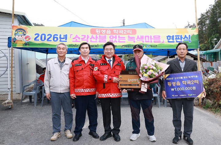 [횡성=뉴시스] 장신상 횡성군수와 관계자들이 학곡2리 마을회관에서 열린 '소각 산불 없는 녹색마을' 현판식에서 기념촬영을 하고 있다. (사진=횡성군 제공) 2026.10.20. photo@newsis.com *재판매 및 DB 금지