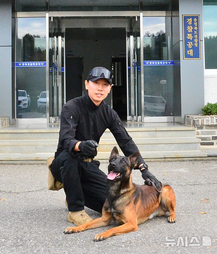 [청주=뉴시스] 서주영 기자 = 오영민 충북경찰특공대 탐지팀장이 지난 19일 특공대 청사 앞에서 파트너 탐지견 디젤과 포즈를 취하고 있다. 2026.10.21. juyeong@newsis.com *재판매 및 DB 금지