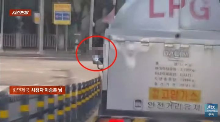 [서울=뉴시스] 부산시 수영구 민락동에서 고압가스 운반차량 운전자가 담배를 피우며 불똥을 차 밖으로 털어내는 모습이 포착됐다. (사진='JTBC 사건반장' 캡처)