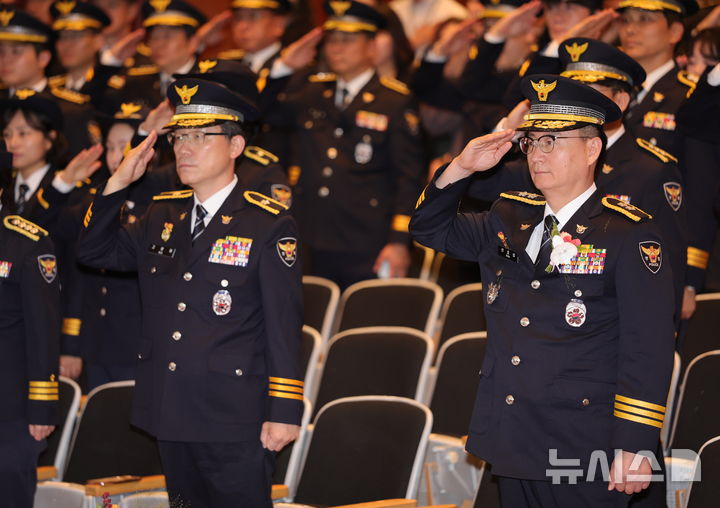 [전주=뉴시스] 김얼 기자 = 신효섭(오른쪽) 전북경찰청장을 비롯한 경찰관들이 21일 전북 전주시 전북경찰청에서 열린 '제81주년 경찰의 날 기념식'에 참석해 국기에 대한 경례를 하고 있다. 2026.10.21. pmkeul@newsis.com