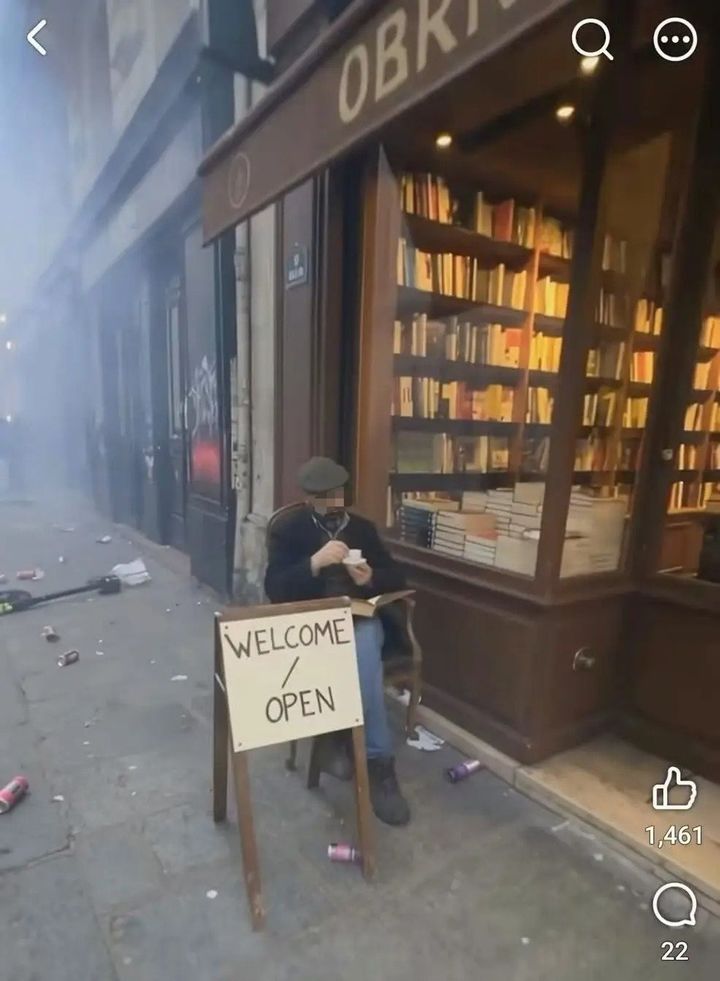 [서울=뉴시스] 프랑스의 한 서점 앞에서 한 남성이 에스프레소를 마시며 책을 읽고 있다. 주변 거리가 폭동으로 어수선해진 가운데 서점은 비교적 평온한 모습을 보이고 있다. (사진출처=SNS 캡처)