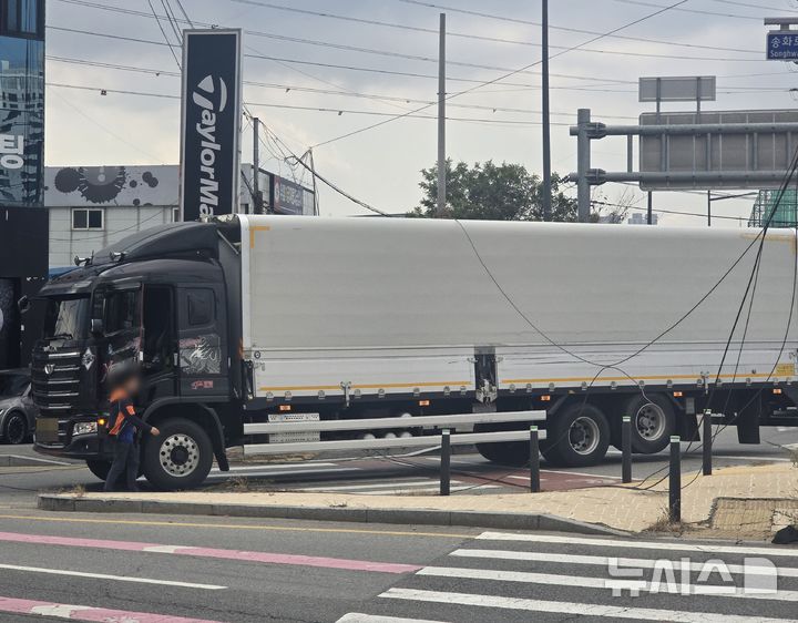 [청주=뉴시스] 21일 오전 충북 청주시 흥덕구 송절교차로에서 화물차가 주행 중 도로에 처진 전선에 걸려 멈춰 있다. (사진=독자 제공) 2026.10.21. photo@newsis.com *재판매 및 DB 금지