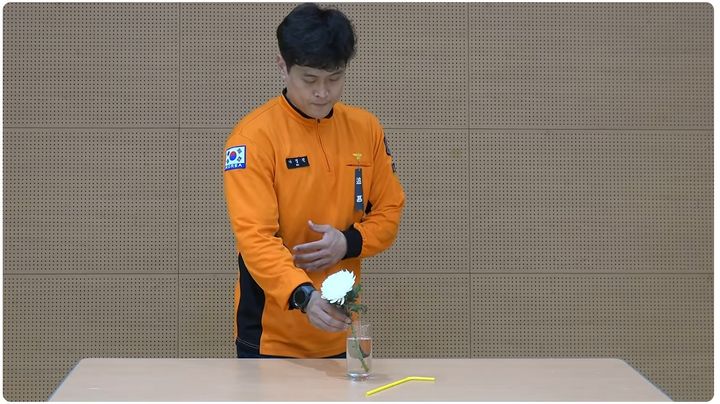 [서울=뉴시스] 이시현 인턴기자 = 유튜브 채널 '소방관 삼촌'에 지난 20일 공개된 영상에서 현직 소방관이 유리컵에 꽂힌 빨대를 빼고 국화꽃을 꽂으며 순직한 고 김진석 소방위을 추모하고 있다. (사진=유튜브 '소방관 삼촌' 캡처) 2026.10.21. *재판매 및 DB 금지