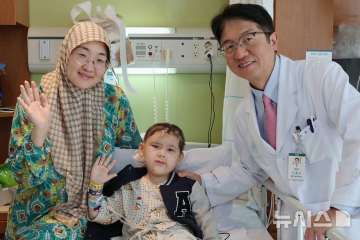 [서울=뉴시스] 대형견 3마리에 공격당해 두개골이 드러날 정도로 두피가 손상된 키르기스스탄 아이 우마르(6)군이 한국에서 재건술을 성공적으로 받았다. (왼쪽부터) 우마르의 엄마, 우마르, 최종우 서울아산병원 성형외과 교수가 우마르의 퇴원을 기념하며 기념사진을 촬영하고 있다. (사진= 서울아산병원 제공) 