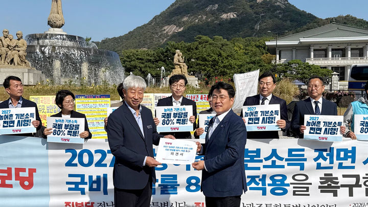 [무안=뉴시스] 전남광주통합특별시의회 박형대(진보당·장흥1) 의원이 21일 청와대 앞에서 2027년 농어촌기본소득 전면 시행과 국비 부담률 80% 적용을 촉구하는 요구안을 이영수 청와대 농림축산비서관에게 전달하고 있다. (사진=진보당 제공) photo@newsis.com *재판매 및 DB 금지