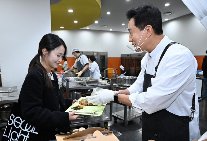 [서울=뉴시스] 오세훈 서울시장이 21일 서울시청 본관 구내식당에서 직원들에게 '서울 달빛야장' 특별식 메뉴인 가지튀김을 배식하고 있다. (사진=서울시 제공) 2026.10.21. photo@newsis.com *재판매 및 DB 금지