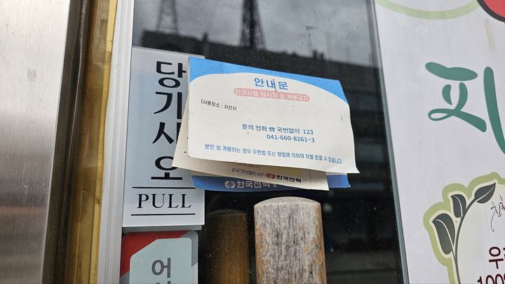 [서산=뉴시스] 김덕진 기자=지난 19일 충남 서산 대산석유화학단지 위기가 지역사회 전반으로 번지고 있는 가운데 문을 닫은지 몇 달 된 듯 보이는 대산읍내 도로변 한 상가 출입문에 한전 안내문이 붙여 있다. 2026.10.22. spark@newsis.com *재판매 및 DB 금지