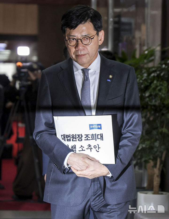 [서울=뉴시스] 정병혁 기자 = 김준형 조국혁신당 원내대표가 21일 서울 여의도 국회에서 조희대 대법원장 탄핵과 관련해 한병도 더불어민주당 원내대표와 논의하기 위해 탄핵소추안을 들고 이동하고 있다. 2026.10.21. jhope@newsis.com