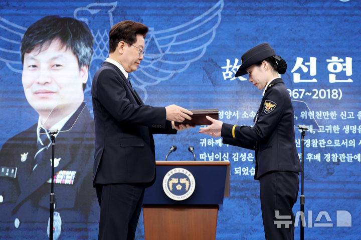 [서울=뉴시스] 조성봉 기자 = 이재명 대통령이 21일 서울 서대문구 경찰청에서 열린 제81주년 경찰의 날 기념식에서 경감 김선현의 딸 김성은 씨에게 경찰영웅 인증패를 전달하고 있다. 2026.10.21. suncho21@newsis.com