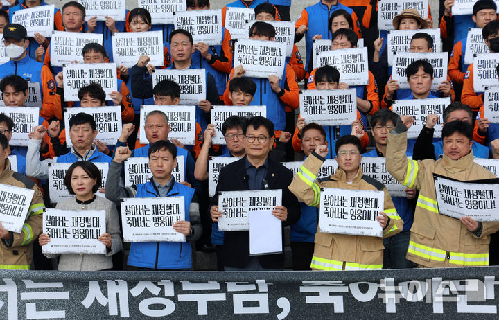 [서울=뉴시스] 고범준 기자 = 송영길 더불어민주당 의원과 대한민국공무원노동조합총연맹 소방공무원노동조합이 21일 서울 여의도 국회 본관 앞 계단에서 열린 소방공무원 명예회복 및 소방조직 재정 책임 정상화 촉구 기자회견에서 구호를 외치고 있다. 2026.10.21. bjko@newsis.com