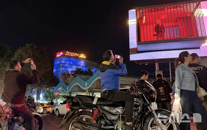 [테헤란=AP/뉴시스] 21일(현지 시간) 이란 테헤란 타지리시 광장에서 시민들이 감옥을 본뜬 광고판 내 도널드 트럼프 미국 대통령을 연기한 배우가 철창에 갇혀 있는 모습을 사진 찍고 있다. 2026.10.23.