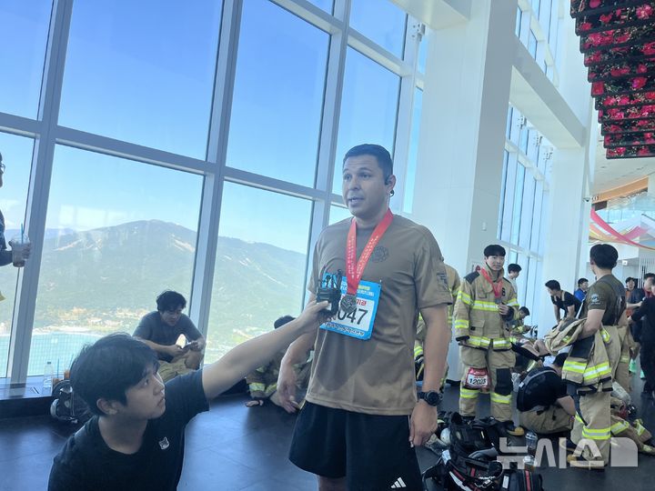 [부산=뉴시스] 진민현 기자 = 22일 오전 부산 해운대구 엘시티(LCT) 랜드마크 건물에서는 총 101층, 2372개의 계단을 오르는 '전국소방공무원 해운대 LCT 계단오르기 대회'가 개최된 가운데 올해 처음 참가한 후안 P. 로드리게스 주한미군 대구기지사령부 소방대장이 참여 소감을 말하고 있다. 2026.10.22 truth@newsis.com